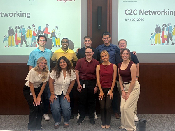 A group of Vanguard interns poses for a photo in a conference room following a networking event. Two presentation screens behind the group display a slide titled “C2C Networking” with Vanguard branding and the date June 9, 2026. The interns stand in front of the screens wearing business casual attire during the summer internship program.