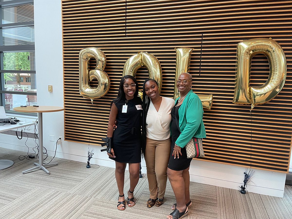 Alexis W. with BOLD members in front of BOLD sign at Vanguard campus