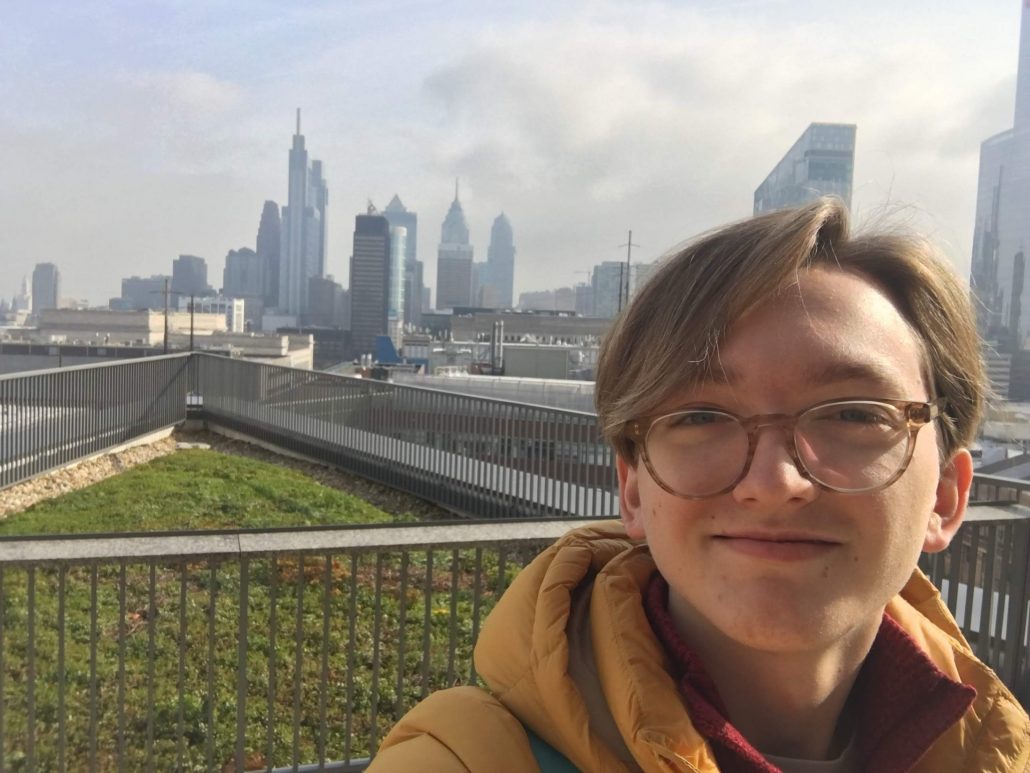 closeup of Zachary K. in front of Philadelphia skyline