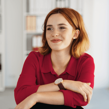 Woman looking away from the camera while smiling, looking content.