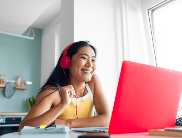 A female student smiling while attending a virtual conference. 
