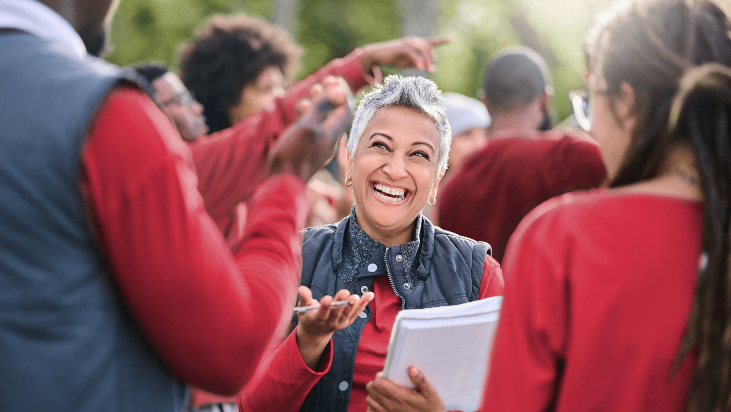 Woman holding a checklist and laughing while she volunteers with coworkers.
