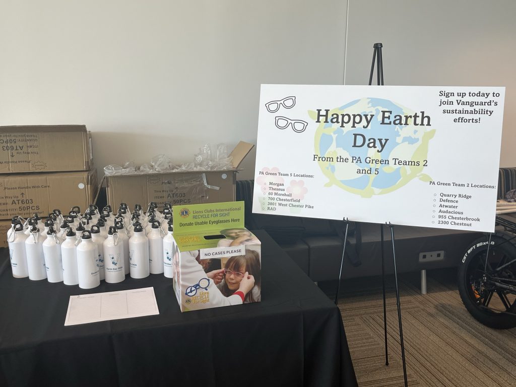 Sign that says “Happy Earth Day” with water bottles on table 