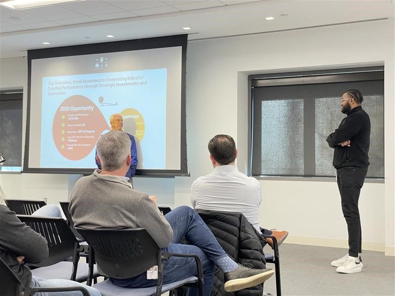 Quentin standing in the front of a conference room during a presentation 